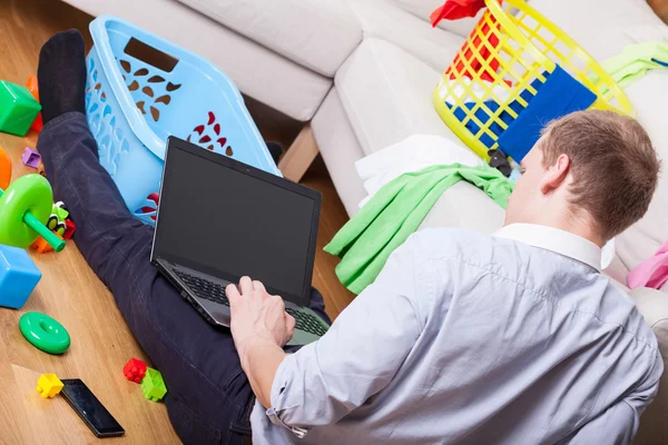 Человек с ноутбуком сидит на полу — стоковое фото
