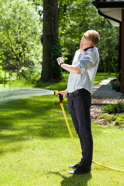 Elegante man de planten water geven — Stockfoto