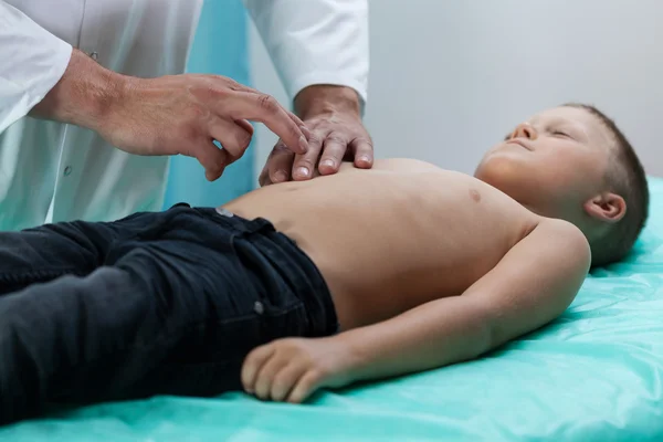 Doctor checking boy belly — Stock Photo, Image