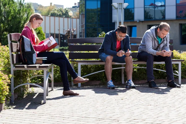 Garçons utilisant les téléphones et l'apprentissage des filles — Photo