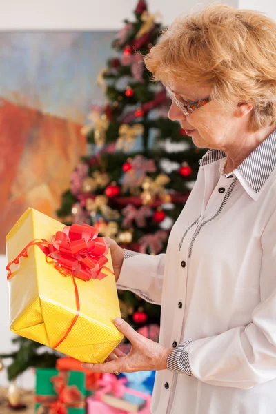 クリスマスのギフトを保持している年配の女性 — ストック写真