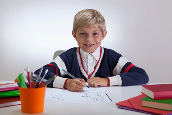 Sonriente escritura infantil en la escuela — Foto de Stock