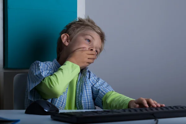 Bostezando niño usando la computadora — Foto de Stock