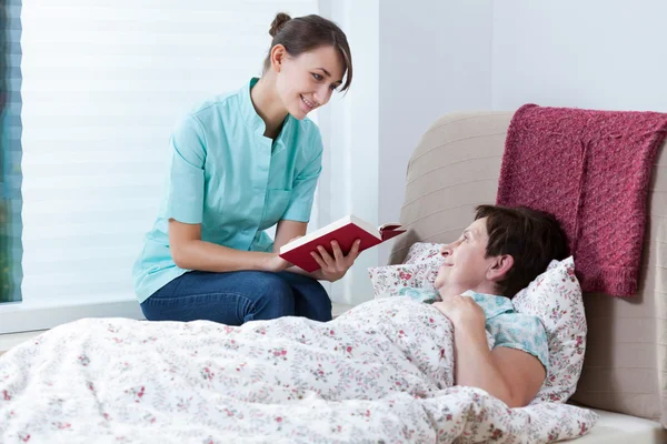 Helpful nurse reading book — Stock Photo, Image