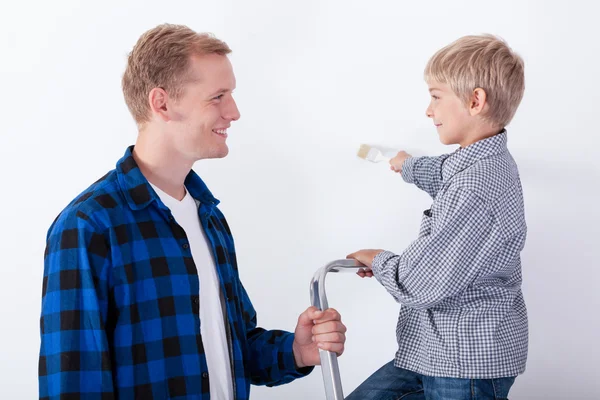 Pai aprendendo seu filho pintando uma parede — Fotografia de Stock