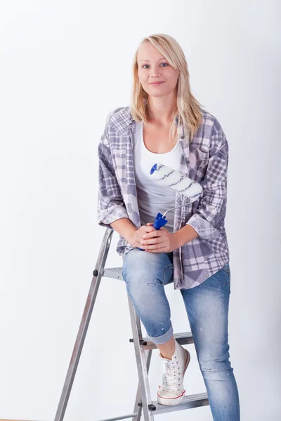 Jonge vrouw op een ladder — Stockfoto