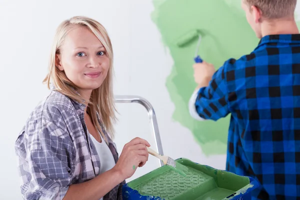 Mujer sonriente sosteniendo bandeja de pintura — Foto de Stock