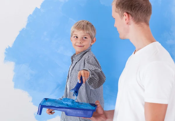 Boy painting wall with father — Stock Photo, Image