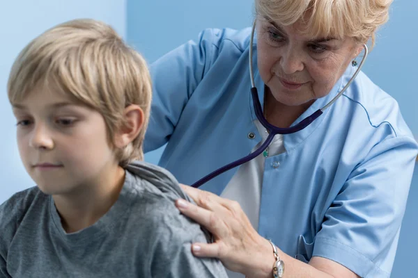 Pediatra auscultando as costas — Fotografia de Stock