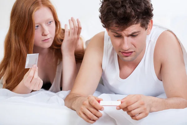 Scared man holding positive pregnancy test — Stock Photo, Image