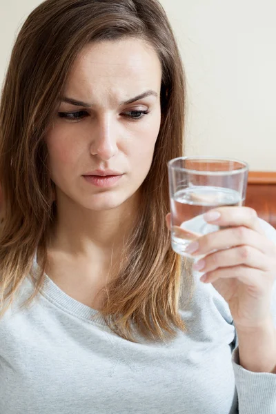 Mujer enferma sosteniendo un vaso de agua — Foto de Stock