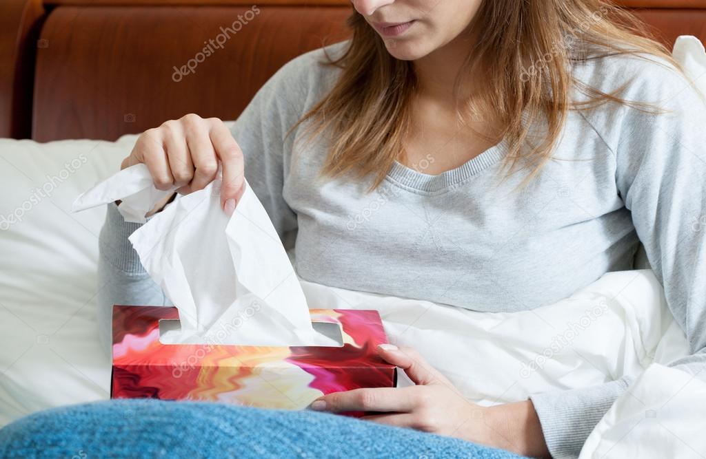 Sick woman with box of tissues