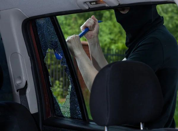 Einbrecher schlägt mit Brechstange Autoscheibe ein — Stockfoto