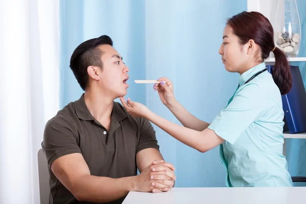 Asian man during throat examination — Stock Photo, Image