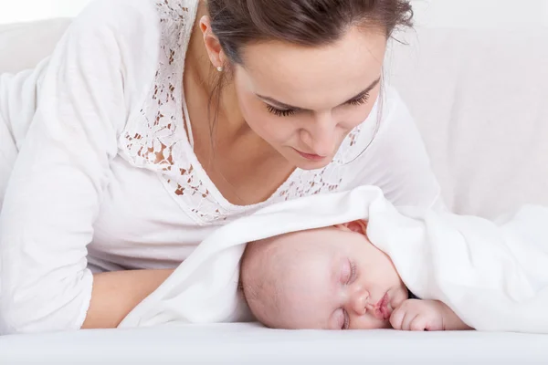 Mamma tittar på sin sovande baby — Stockfoto