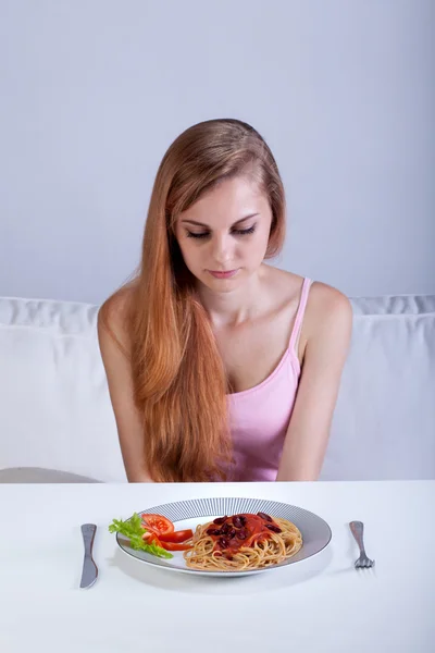 Menina sentada na frente do prato de jantar — Fotografia de Stock