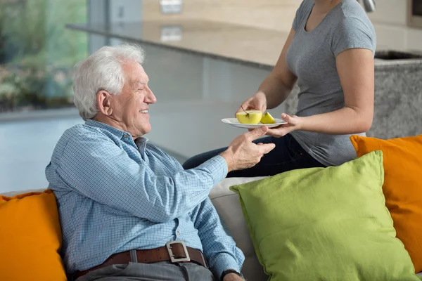 Tochter gibt kranken Opa Apfel — Stockfoto