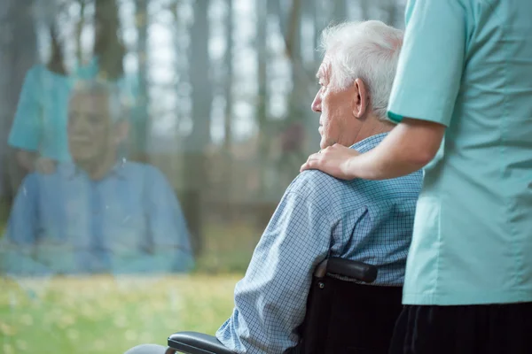 Sjuksköterska medhjälpande senior mannen — Stockfoto