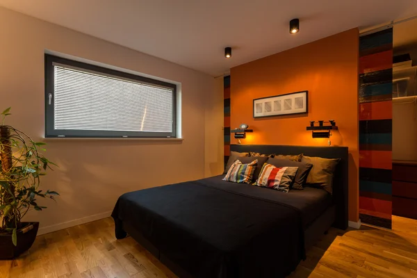 Designer bedroom with orange wall — Stock Photo, Image