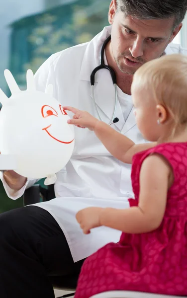 Bambina che gioca con il suo pediatra — Foto Stock