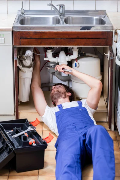 Handyman fixing a sink with pilers Royalty Free Stock Images