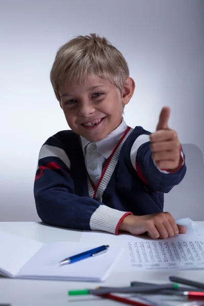 Malý školák ukazuje palec — Stock fotografie