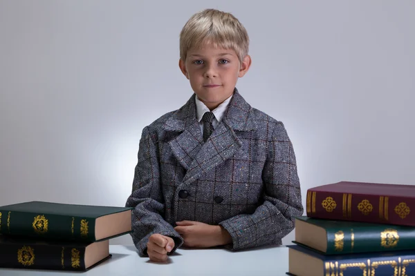 Allvarlig pojke bland böcker — Stockfoto