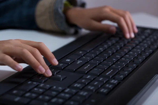 Mãos de menino digitando no teclado — Fotografia de Stock