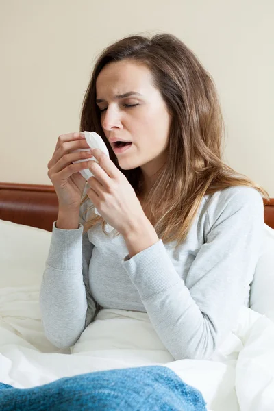 Frau niest im Bett — Stockfoto