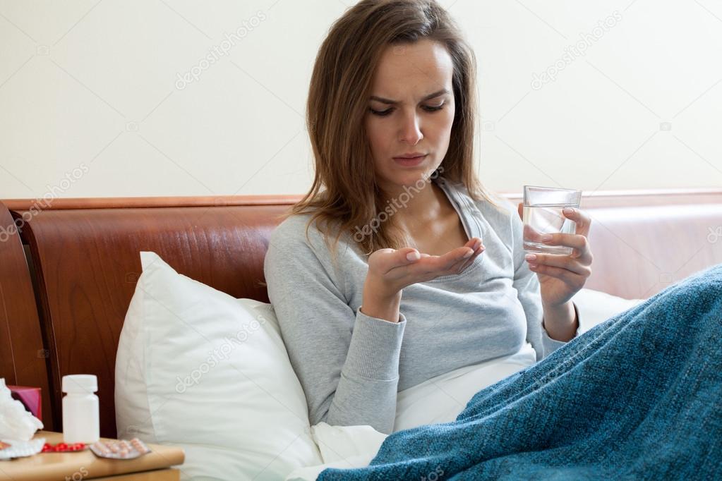 Sick woman taking medicine