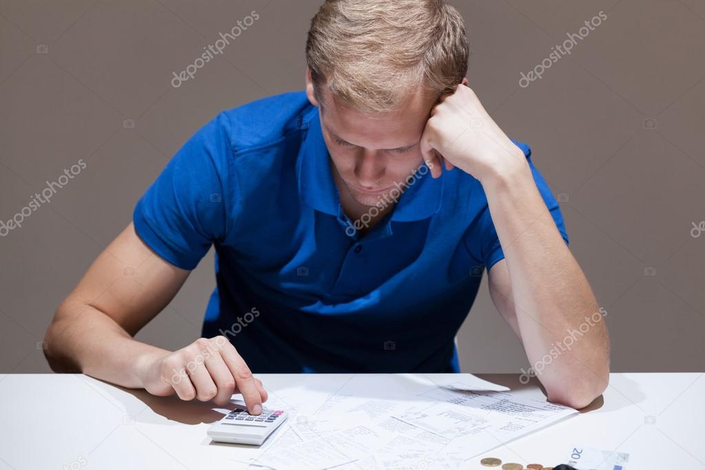 Upset man using calculator