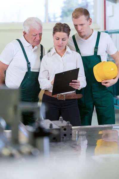 Female engineer and manufacturing labourers — Stock Photo, Image