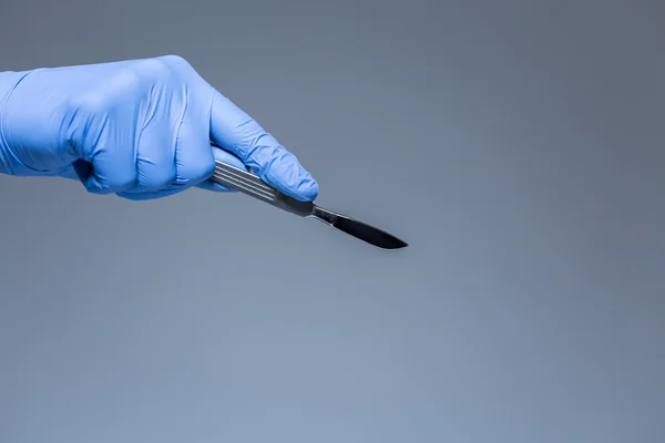 Рука хирурга со скальпелем — стоковое фото