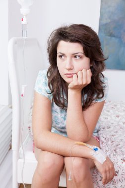 Hasta yatağı üzerinde oturan sıkılmış