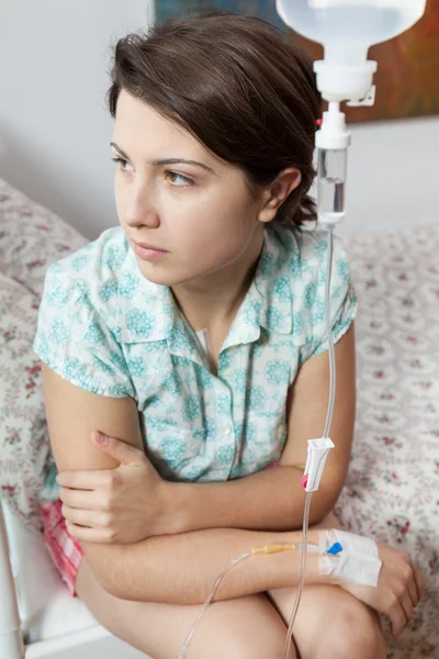 Chica triste sentada en la cama en el hospital — Foto de Stock