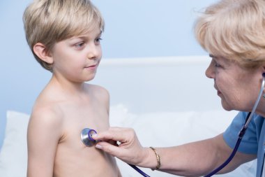 Çocuğun doktor stetoskop kullanarak