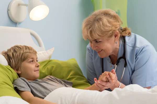 Pediatrician holding hand of her patient — Stock Photo, Image