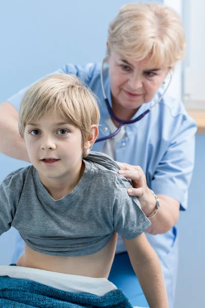 Médico del niño auscultando la espalda — Foto de Stock