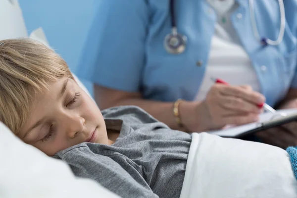 Ungen sover i sjukhussäng — Stockfoto