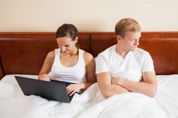 Woman online and a bored man — Stock Photo, Image