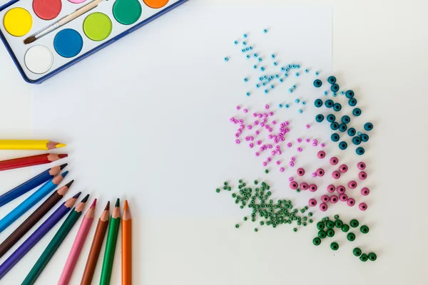 Crayons and paints on a table — Stock Photo, Image