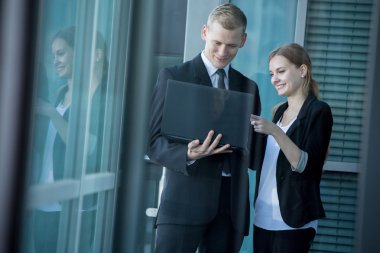 Dizüstü bilgisayar kullanarak gülümseyen Ofis çalışanları