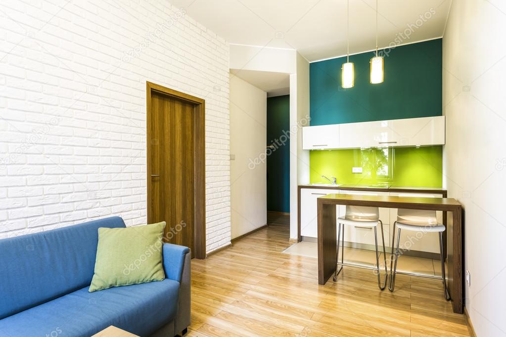 Small living room with green kitchenette