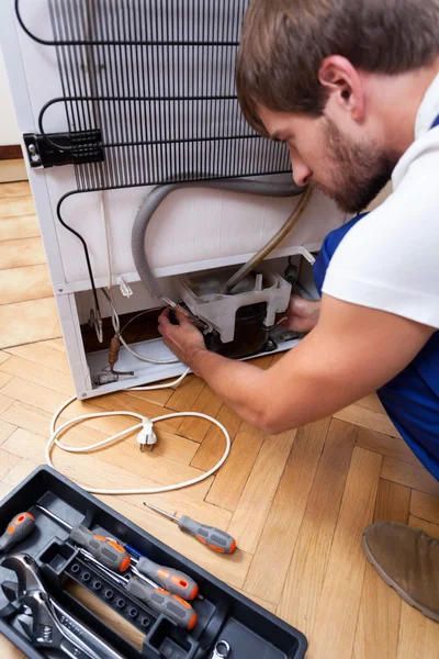 Handyman repairs the fridge — Stock Photo, Image
