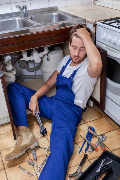 Різноробочий сидячи на підлогу на кухні — стокове фото