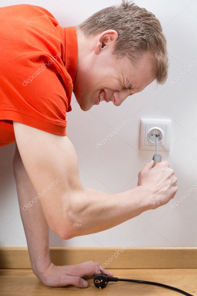 Man fixing socket being electrocuted Stock Photo by photographee