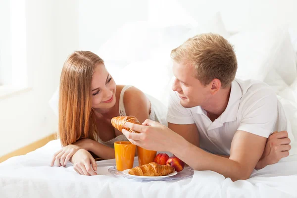 Man utfodring kvinna med croissant — Stockfoto