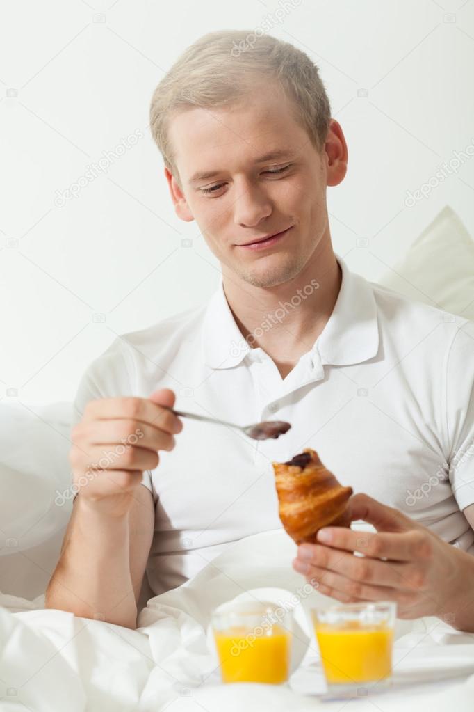Men eating breakfast in bed