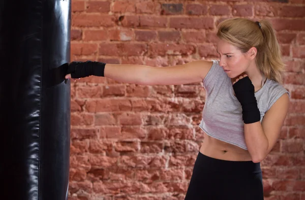 Chica de entrenamiento con saco de boxeo —  Fotos de Stock