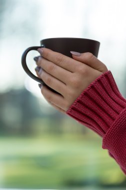 Kırmızı kazaklı Kupası tutan kadın